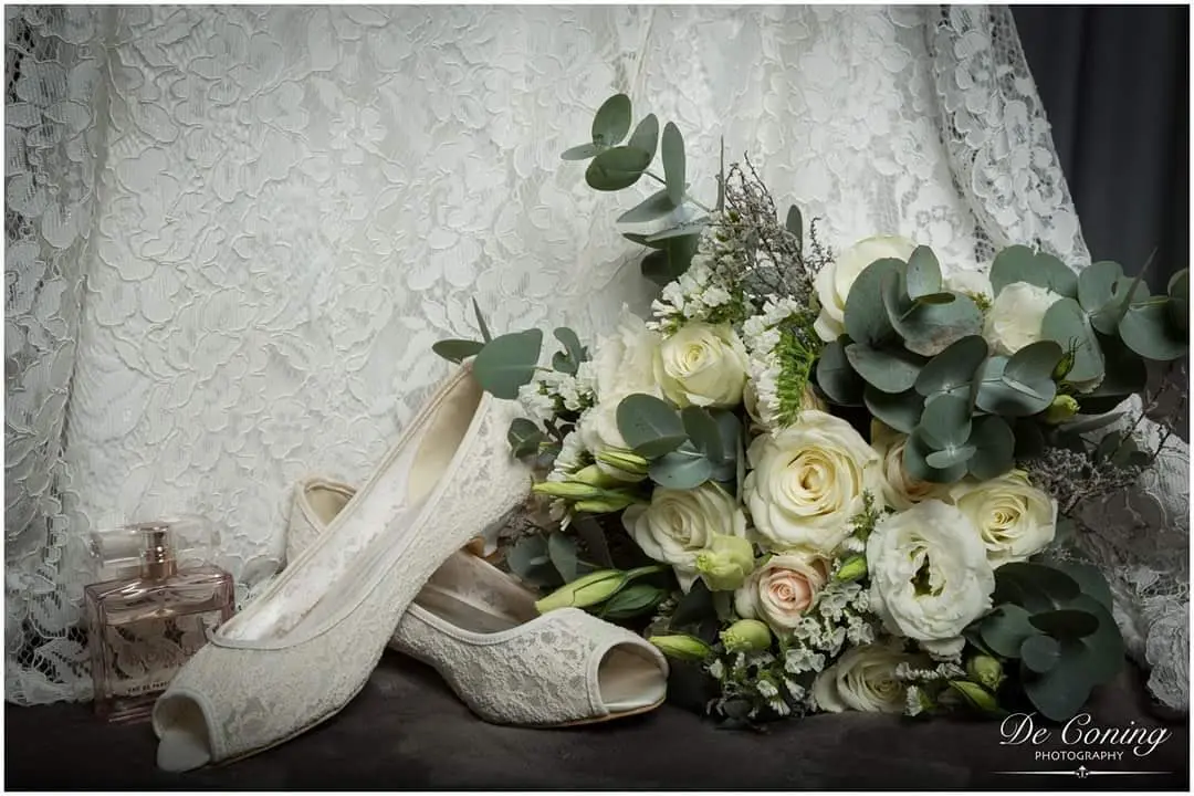 Artisanal wedding bouquet paired with delicate bridal lace shoes
