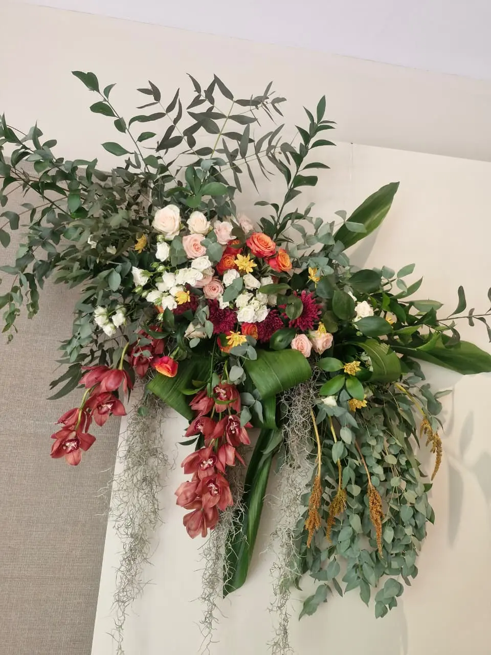 Grand floral chandelier canopy hanging above wedding reception tables