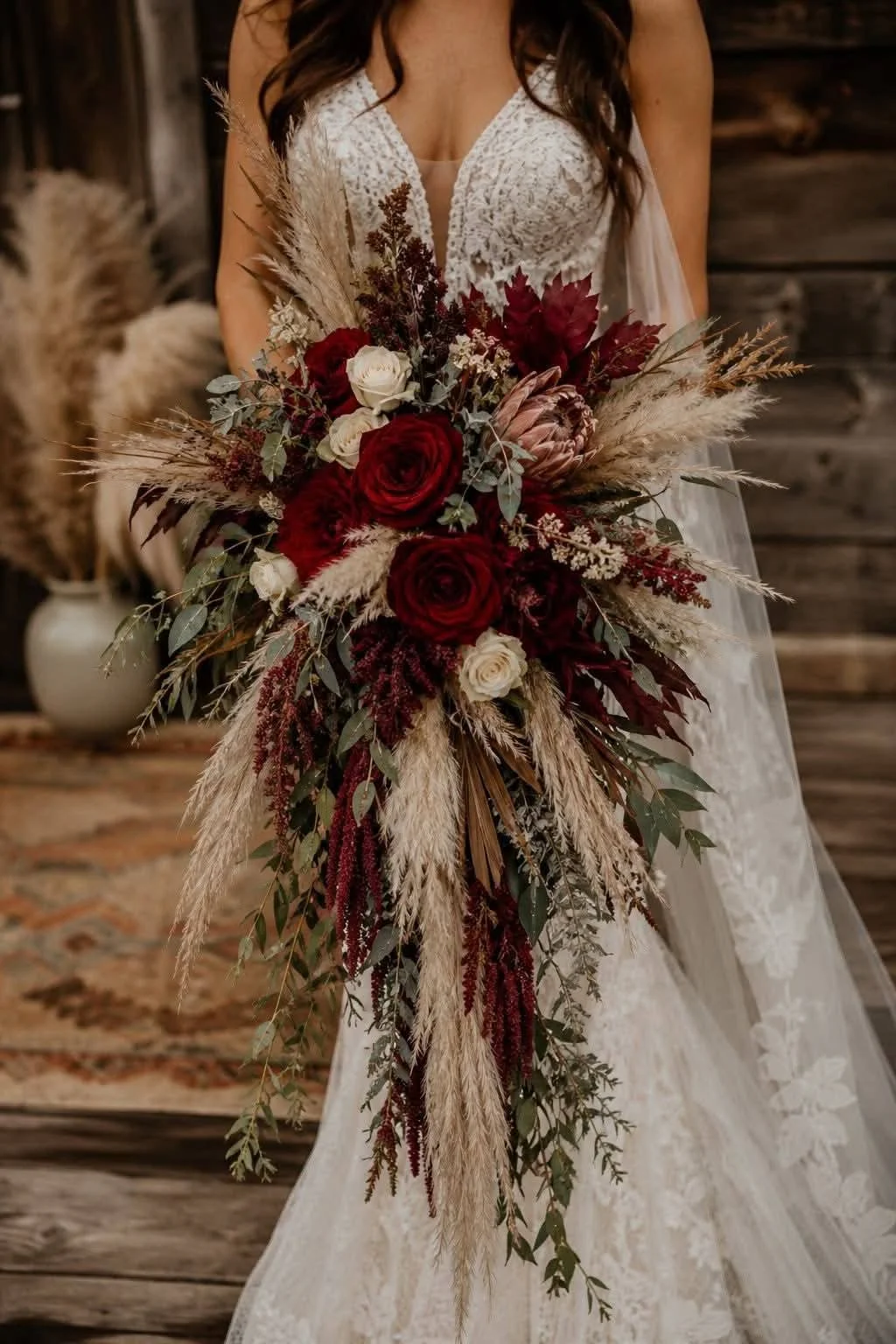 Burgundy rose and pampas cascading bridal bouquet with protea