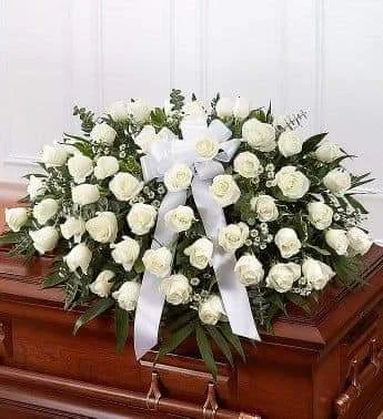 White rose funeral casket spray with white ribbon