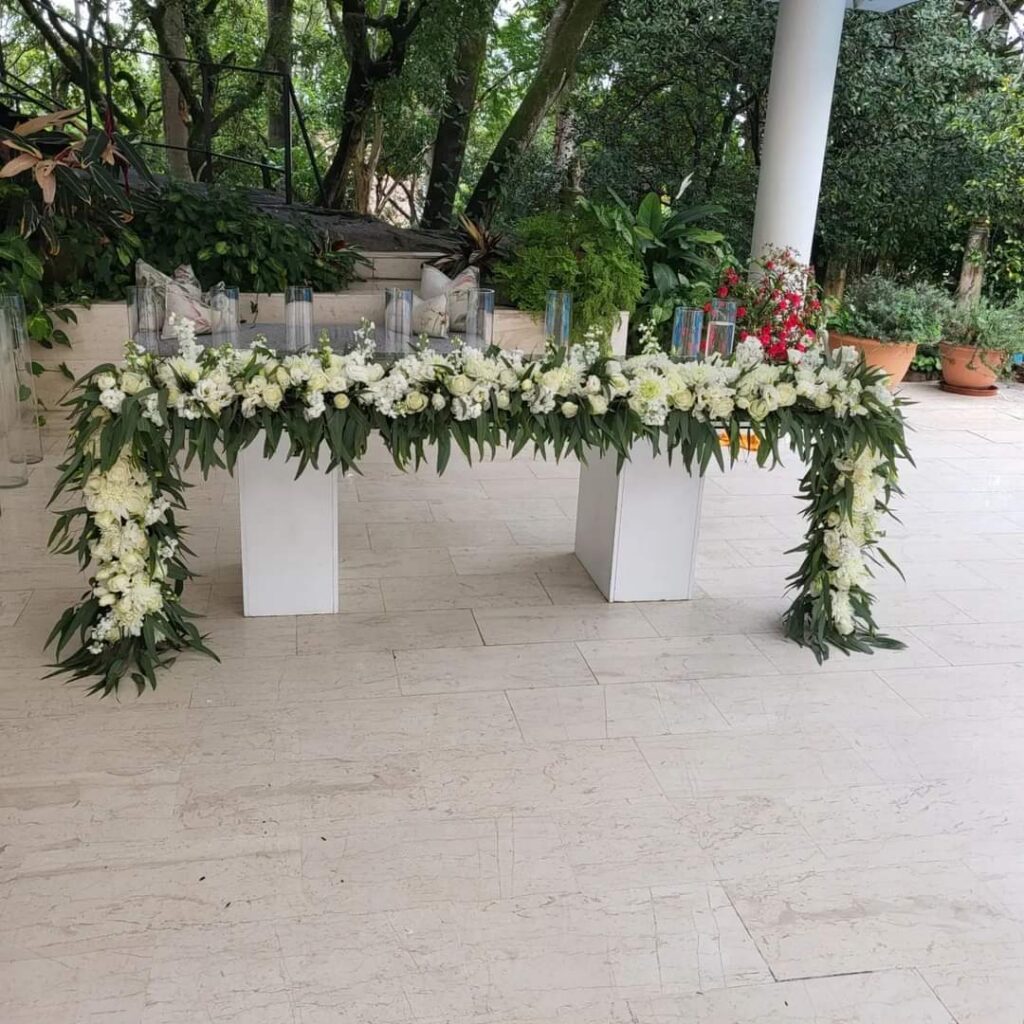 Outdoor table decorated with white flowers and greenery