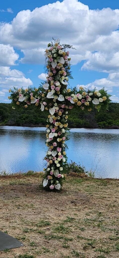 Floral ceremony arch beside the water